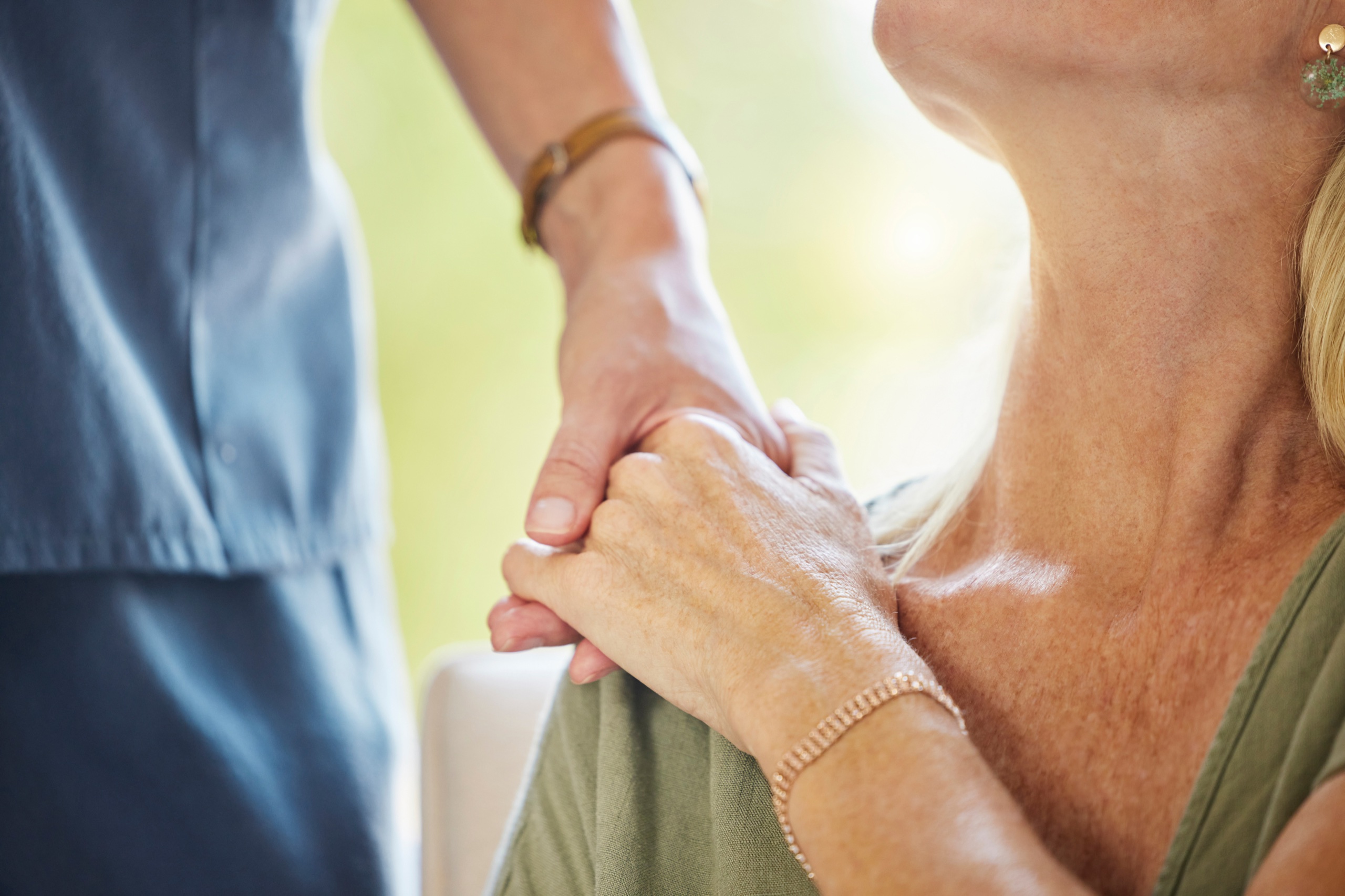 Ein Mensch hält unterstützend die Hand eines anderen Menschen